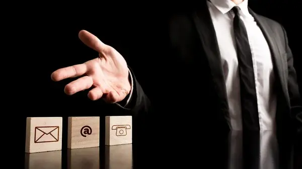 A man in a black suit loosening his tie